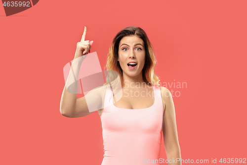 Image of Beautiful woman looking suprised isolated on coral