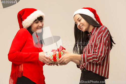 Image of Happy family in Christmas sweater posing on a red background in the studio.