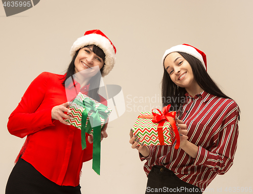 Image of Happy family in Christmas sweater posing on a red background in the studio.