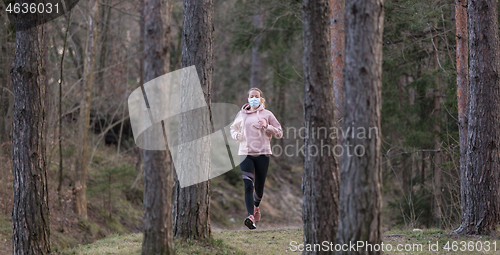 Image of Corona virus, or Covid-19, is spreading all over the world. Portrait of caucasian sporty woman wearing a medical protection face mask while running in nature.