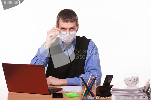 Image of Clerk in a medical mask lowered his glasses from eye to nose