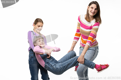 Image of Mom with the eldest daughter rock the youngest daughter in her arms