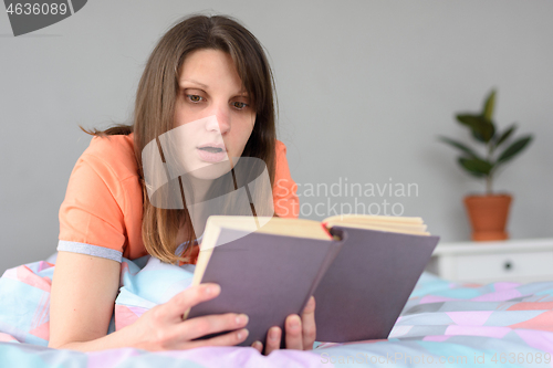 Image of The girl is passionate about reading a book and worries about heroes