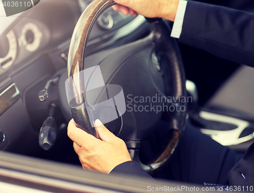 Image of senior businessman hands driving car