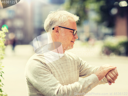 Image of senior man checking time on his wristwatch