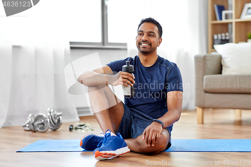 Image of indian man drinking water after training at home