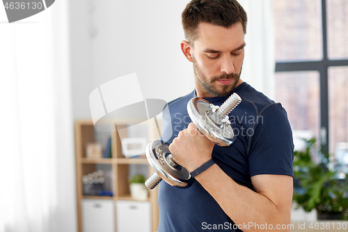 Image of man exercising with dumbbell at home