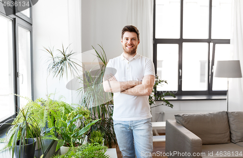 Image of smiling man with houseplants at home