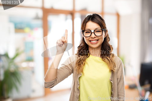 Image of asian woman in glasses with finger up at office