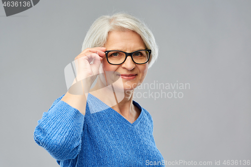 Image of portrait of senior woman in glasses over grey