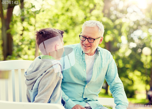 Image of grandfather and grandson talking at summer park