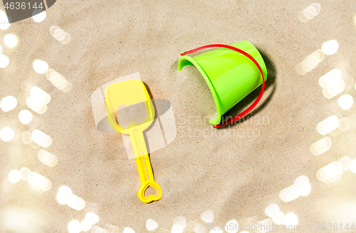 Image of toy bucket and shovel on beach sand