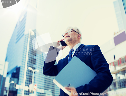 Image of senior businessman calling on smartphone in city