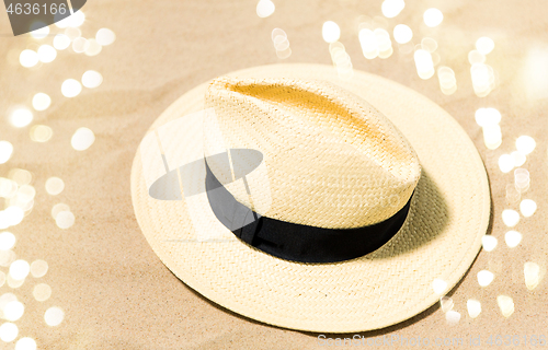 Image of straw hat on beach sand