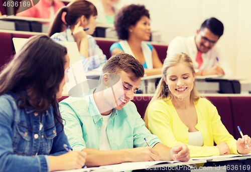 Image of group of students with notebooks in lecture hall