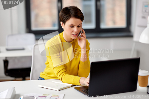 Image of businesswoman with laptop calling on smartphone