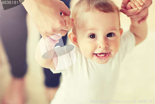 Image of happy baby learning to walk with mother help