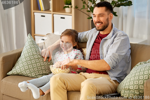 Image of happy father and daughter watching tv at home