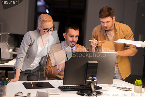 Image of business team with computer working late at office