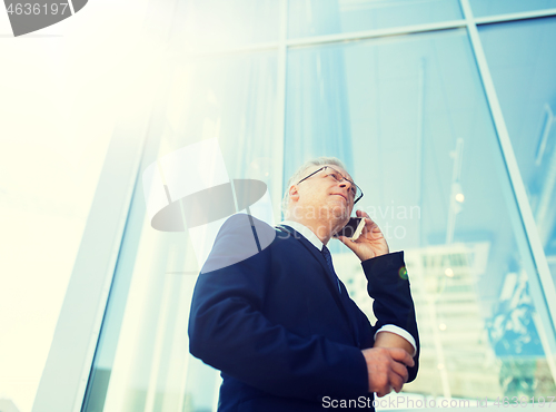 Image of senior businessman calling on smartphone in city