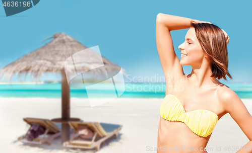 Image of young woman posing in bikini on beach