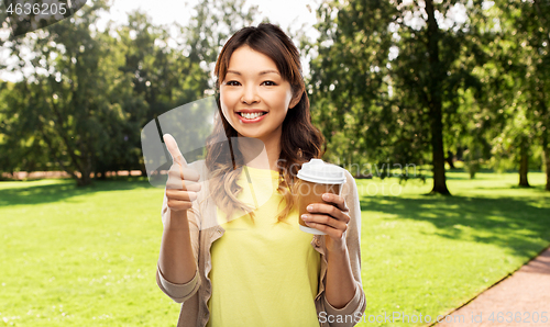 Image of asian woman drinking coffee and showing thumbs up