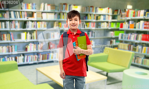 Image of smiling student boy with books at library
