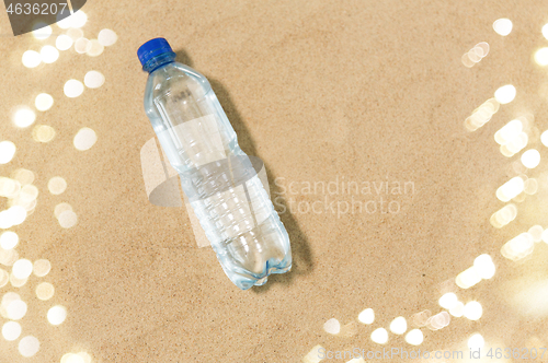 Image of bottle of water on beach sand