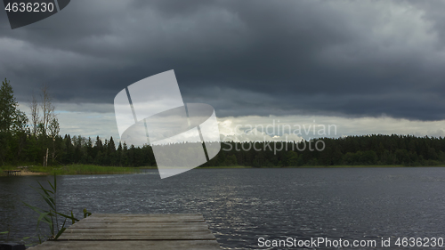 Image of Dark Overcast Sky With Thunderclouds Over The Forest Lake