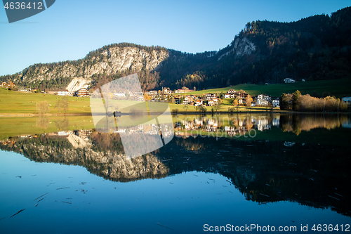 Image of Beautiful landscape with country area near the lake and reflection in it.