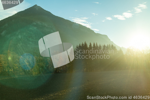 Image of Mountain landscape with forest area on a background of sun light, Austria.