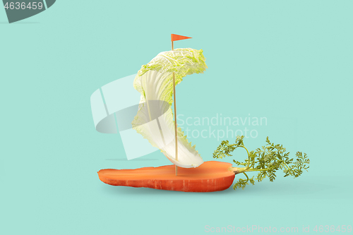 Image of Vegan sailboat from organic vegetables on a pastel turquoise background.