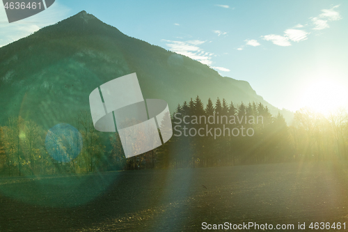 Image of Mountain landscape with forest area on a background of sun light, Austria.