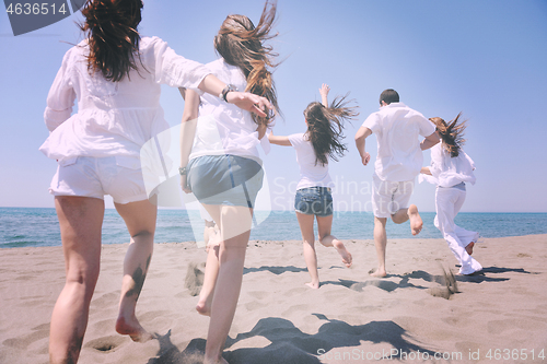 Image of happy people group have fun and running on beach