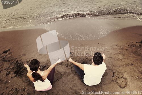 Image of couple yoga beach