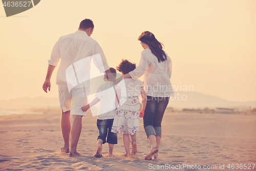 Image of happy young family have fun on beach at sunset