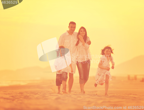 Image of happy young family have fun on beach at sunset