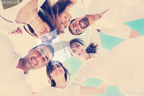 Image of Group of happy young people in circle at beach