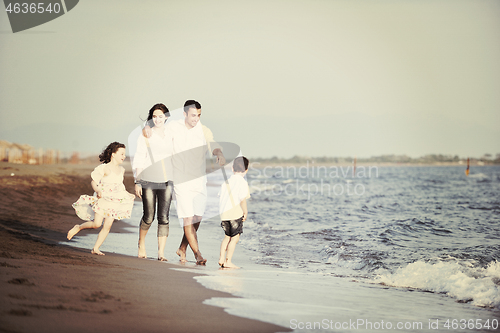 Image of happy young family have fun on beach at sunset