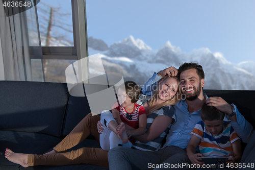 Image of happy young couple spending time with kids at home