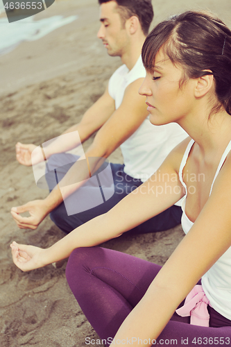 Image of couple yoga beach