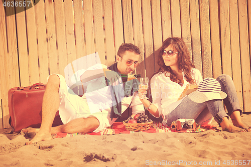 Image of young couple enjoying  picnic on the beach