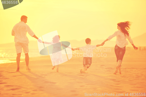 Image of happy young family have fun on beach at sunset