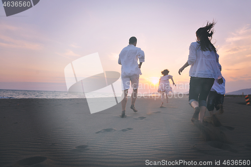 Image of happy young family have fun on beach at sunset