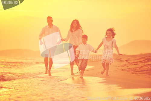 Image of happy young family have fun on beach at sunset