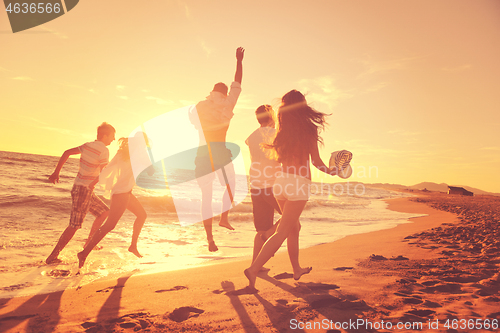 Image of people group running on the beach