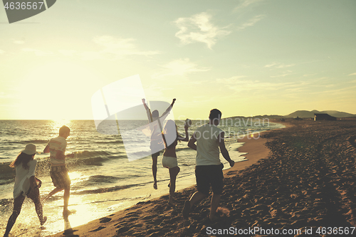 Image of people group running on the beach