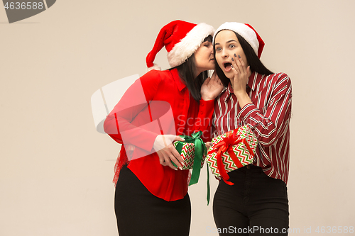 Image of Happy family in Christmas sweater posing on a red background in the studio.