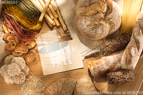 Image of Gluten free food. Various pasta, bread and snacks on wooden background from top view