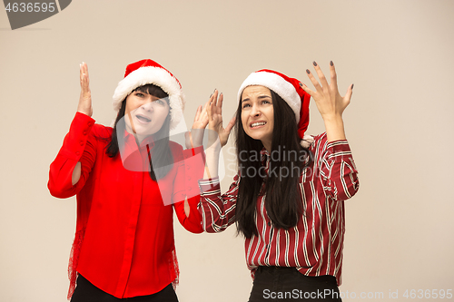 Image of Happy family in Christmas sweater posing on a red background in the studio.